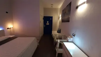 a bedroom with a bed and a table and a blue door at Youth Station Hostel in Rome