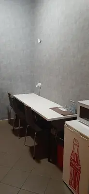 a white table with chairs next to a refrigerator at Youth Station Hostel in Rome