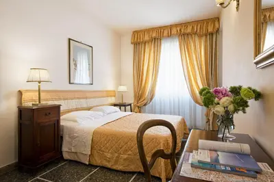 a hotel room with a bed and a table with a vase of flowers at B&B Le Sibille in Rome