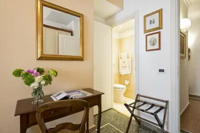 a bathroom with a table with a vase of flowers and a mirror at B&B Le Sibille in Rome
