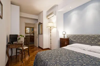 a bedroom with a bed and a desk and a television at B&B Le Sibille in Rome