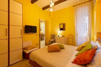 a yellow bedroom with two beds and a television at Domus Clodio in Rome