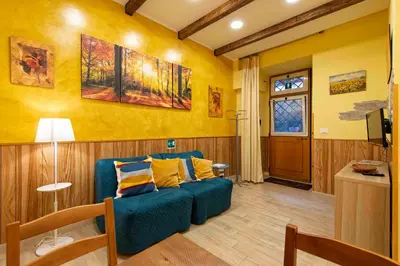 a living room with a blue couch and yellow walls at Domus Clodio in Rome