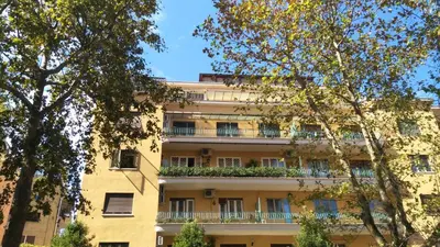 an apartment building with balconies and trees at Trionfal Apartment in Rome