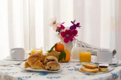 a table with a breakfast of croissants bread and orange juice at Malkavacanze B&B in Rome