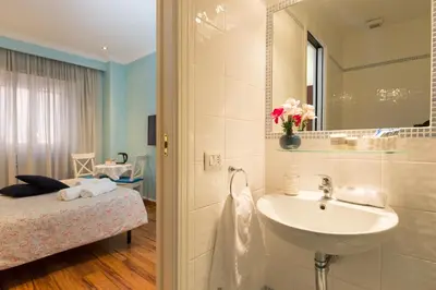 a bathroom with a sink and a bed and a mirror at Malkavacanze B&B in Rome