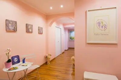 a hallway with pink walls and a table and chairs at Malkavacanze B&B in Rome