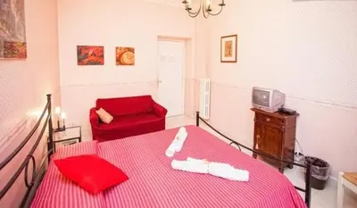 a bedroom with a red bed and a red chair at La Casa Romana in Rome