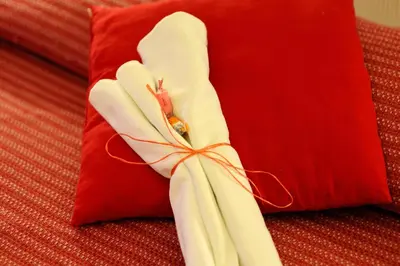 a pair of white gloves sitting on top of a red pillow at La Casa Romana in Rome
