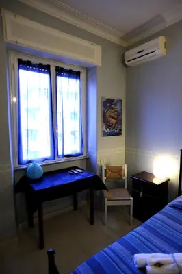 a bedroom with a bed and a desk in the window at La Casa Romana in Rome