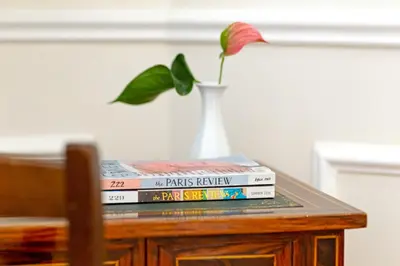 a stack of books sitting on a table with a vase at Casa Cucu Piazza del Popolo in Rome