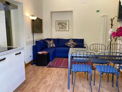 a living room with a blue couch and a table at Otium Maecenatis Apartments in Rome