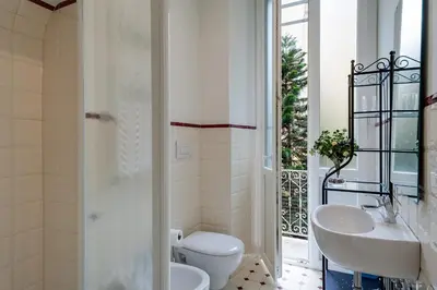 a white bathroom with a toilet and a sink at Otium Maecenatis Apartments in Rome
