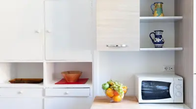 a kitchen with a microwave and a bowl of fruit at Otium Maecenatis Apartments in Rome
