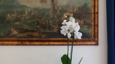 a painting hanging on a wall with a white flower at Otium Maecenatis Apartments in Rome