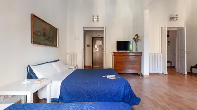 a bedroom with a blue bed and a white table at Otium Maecenatis Apartments in Rome