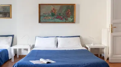 a bedroom with a blue bed with a painting on the wall at Otium Maecenatis Apartments in Rome