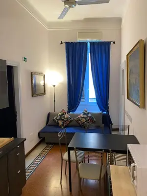 a living room with a blue couch and a window at Otium Maecenatis Apartments in Rome