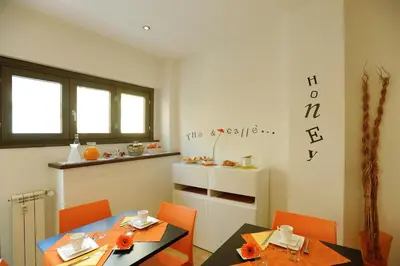 a dining room with two tables and orange chairs at Honey Rooms in Rome