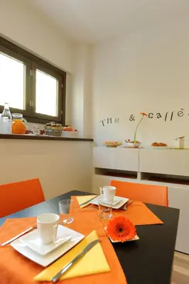 a dining room with a table and a kitchen at Honey Rooms in Rome