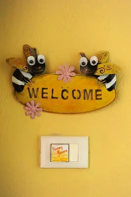 a welcome sign on a wall with a surfboard at Honey Rooms in Rome