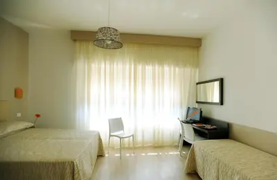 a bedroom with two beds and a desk and a window at Honey Rooms in Rome