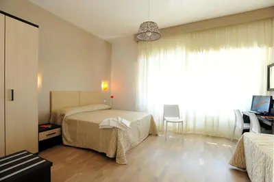 a hotel room with two beds and a desk at Honey Rooms in Rome