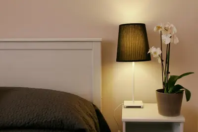 a bedroom with a bed and a lamp and flowers at Roman Suite in Rome