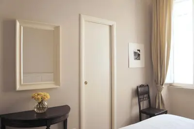 a bedroom with a bed and a table with a mirror at Roman Suite in Rome