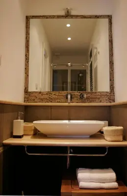 a bathroom with a sink and a large mirror at Roman Suite in Rome