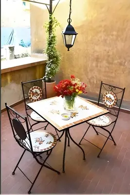 a table and chairs with a vase of flowers at Breakfast In Bed in Rome