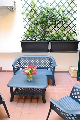 a blue bench with flowers on a patio at Breakfast In Bed in Rome