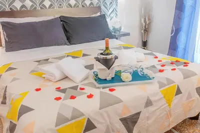 a bed with a tray with a bottle of wine and towels at BB Danilo in Rome