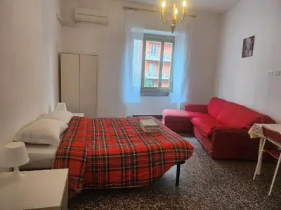 a living room with a bed and a red couch at Sepulveda in Rome