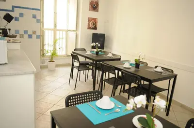 a dining room with tables and chairs and a kitchen at Re Monti in Rome