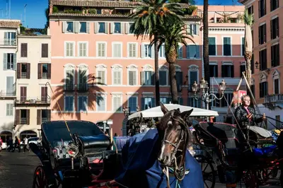 a horse pulling a carriage on a city street at Piazza di Spagna 9 in Rome