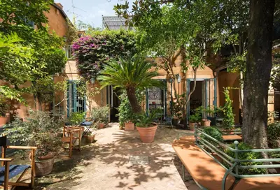 a courtyard with benches and trees and plants at Buonanotte Garibaldi in Rome