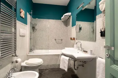 a bathroom with a toilet and a sink and a tub at Buonanotte Garibaldi in Rome
