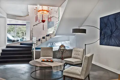 a living room with two chairs and a table and stairs at Hotel Caravel in Rome