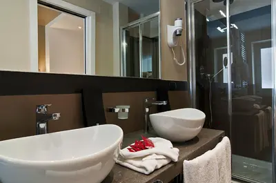 a bathroom with two sinks and a shower at Hotel Caravel in Rome