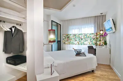 a hotel room with a bed and a suit on a rack at Hotel Caravel in Rome