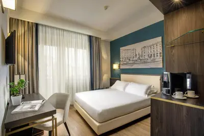 a hotel room with a bed and a desk at Hotel Santa Costanza by OMNIA hotels in Rome