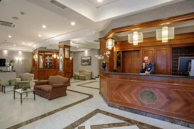 a man talking on a cell phone in a lobby at Hotel Santa Costanza by OMNIA hotels in Rome