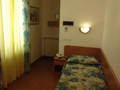 a small room with a bed and a telephone at Hotel Tirreno in Rome