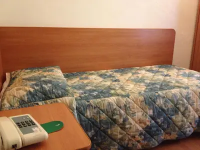 a bedroom with a bed with a remote control on a table at Hotel Tirreno in Rome