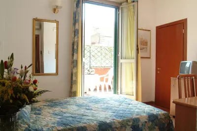 a bedroom with a bed and a large window at Hotel Tirreno in Rome