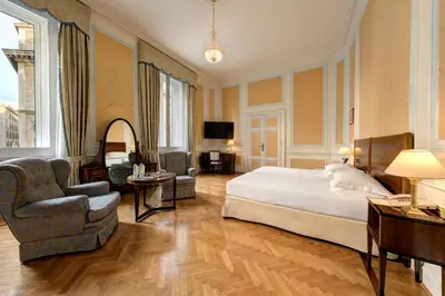 a hotel room with a bed and a chair at Hotel Quirinale in Rome