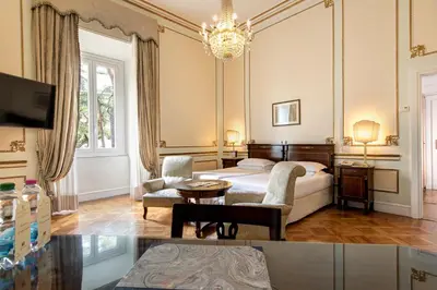 a hotel room with a bed and a chandelier at Hotel Quirinale in Rome