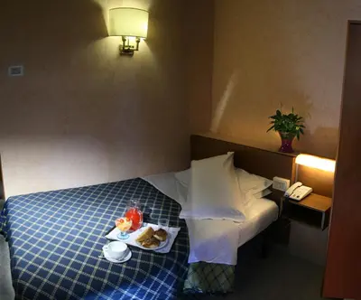 a hotel room with a bed with a tray of food on it at Hotel Delle Muse in Rome