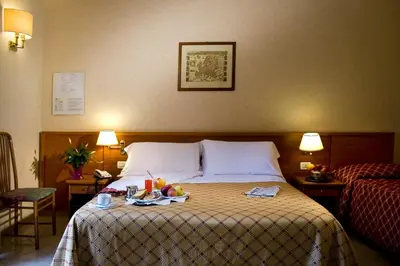a hotel room with a bed with a tray of fruit on it at Hotel Delle Muse in Rome